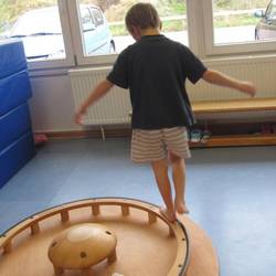 Ein Kind balanciert auf einem Kreisel vom Hengstenberg- Bewegungsmaterial.