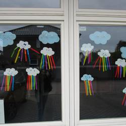 Kinder haben zu Hause eine Wolke mit Regenbogen gebastelt.
