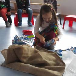 Ein Kind packt die Geschenke aus