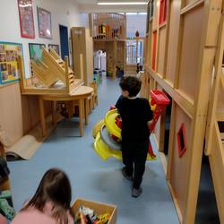 Kinder transportieren die Spielmaterial in den Gruppenraum